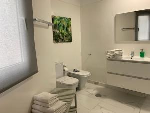 Baño blanco con aseo y lavamanos en Apartamentos Bruja, en Santa Cruz de Tenerife