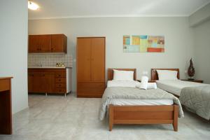a bedroom with two beds and a kitchen at Panorama Siviris in Siviri