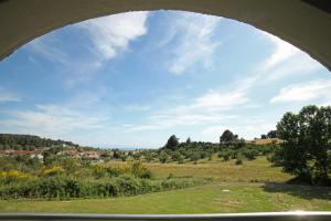 a view of a field through a archway at Panorama Siviris in Siviri