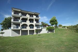 a building on a hill with a large grass field at Panorama Siviris in Siviri