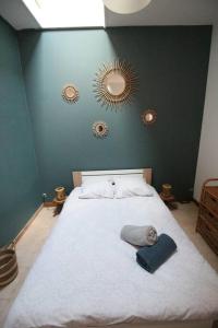 een slaapkamer met een wit bed en 2 spiegels aan de muur bij L'étape Bessièraine: Toulouse, Albi et Montauban in Bessières