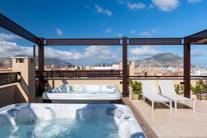 a hot tub on a balcony with a view of the city at Solemar Sicilia - Multi Suite in Palermo