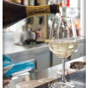 una botella de vino vertida en una copa de vino en Hotel Sabbia d'Oro en Rímini