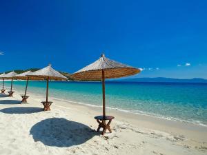 a row of umbrellas on a beach with the ocean at Panorama Siviris in Siviri