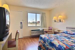 a hotel room with a bed and a television at Motel 6-Albuquerque, NM - South - Airport in Albuquerque