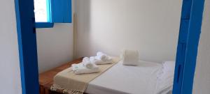 a room with a bed with white towels on it at Casinha do Bem-Viver na Vila de Itaúnas in Itaúnas
