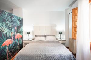 a bedroom with a large bed with a tropical wallpaper at PAVANERAS - Ubicación inmejorable in Granada
