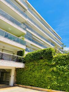 a building with a green hedge in front of it at Floriana in Cannes