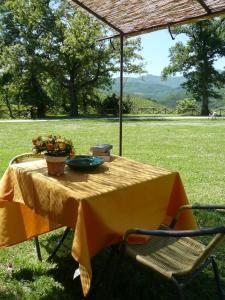uma mesa com uma toalha de mesa amarela num campo em Ca' le Suore em Cagli