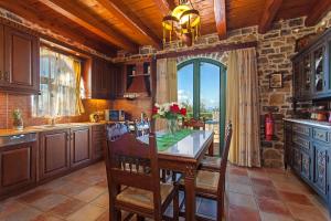 a kitchen with a table and a large window at Villa Antina by PosarelliVillas in Litsárdha