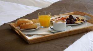 a tray with breakfast foods and a glass of orange juice at Fay Victoria Beach in Rincón de la Victoria
