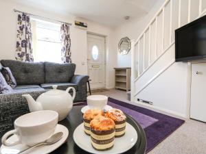 uma sala de estar com uma mesa de centro com queques em Kingfisher Cottage em Weymouth