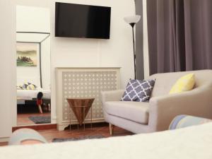 sala de estar con sofá y TV en la pared en Firenze Rentals Suite Cavour, en Florencia