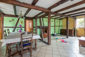 ein Esszimmer mit einem Tisch in einem Zimmer mit grünen Wänden in der Unterkunft L'Audacieuse in Eckbolsheim