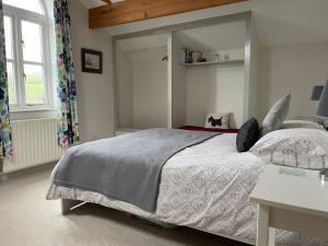 a bedroom with a large bed and a window at Stables Cottage in East Norton