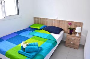 sypialnia z kolorowym łóżkiem z ręcznikami i szafką nocną w obiekcie Ferienwohnung CENTRAL - COSTA CALMA - WiFi - Innenstadt w mieście Costa Calma