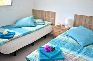 2 łóżka w pokoju z niebieskimi poduszkami w obiekcie Ferienwohnung CENTRAL - COSTA CALMA - WiFi - Innenstadt w mieście Costa Calma