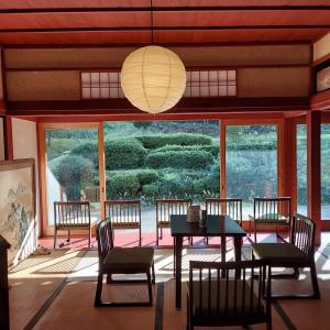 a dining room with a table and chairs and a large window at 泰山木美山 in Nantan city