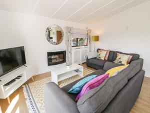 a living room with two couches and a flat screen tv at Summertime Lodge in Abergele