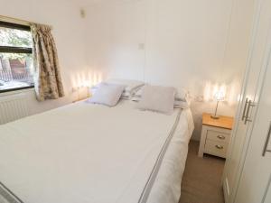 a white bed in a room with a window at Summertime Lodge in Abergele