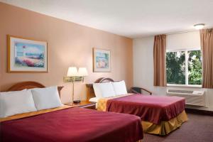 una camera d'albergo con due letti e una finestra di Travelodge by Wyndham Bakersfield a Bakersfield