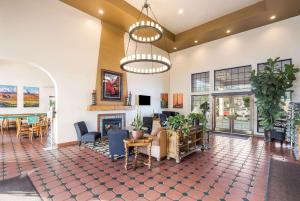 a living room with a fireplace and a table and chairs at Clarion Suites St George - Convention Center Area in St. George