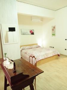 um quarto com uma cama e uma mesa de madeira em Badia em Aversa