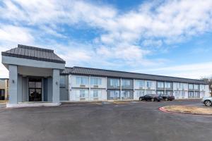 a large building with cars parked in a parking lot at Quality Inn & Suites Sulphur Springs in Sulphur Springs