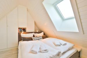 um quarto no sótão com uma cama e uma janela em Appartement Auszeit em Wenningstedt
