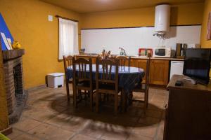 a kitchen with a table and chairs in a room at Casas Rurales El Viejo Castaño 1 in Pujerra