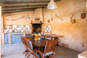 ein Esszimmer mit einem Holztisch und Stühlen in der Unterkunft Cas Padri Teco in Ariany