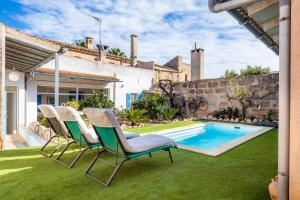 Eine Gruppe von Stühlen steht neben einem Schwimmbecken in der Unterkunft Cas Padri Teco in Ariany