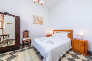 ein Schlafzimmer mit einem Bett, einem Spiegel und einem Stuhl in der Unterkunft Cas Padri Teco in Ariany + 21 Fotos