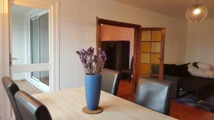 a vase of purple flowers sitting on a table at Près de Melun, Appt 3 pièces 2 chambres tout confort in Dammarie-lès-Lys