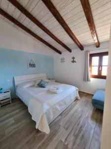 - une chambre avec un grand lit blanc et du parquet dans l'établissement DE MEO Guest House, à Castellammare del Golfo