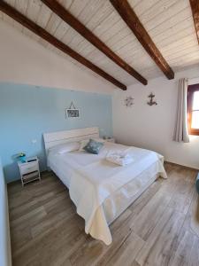 - une chambre avec un grand lit et un plafond en bois dans l'établissement DE MEO Guest House, à Castellammare del Golfo