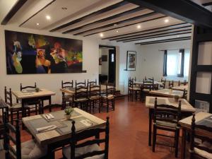 a restaurant with tables and chairs and a painting on the wall at Hotel Rural La Cerámica in Medinaceli