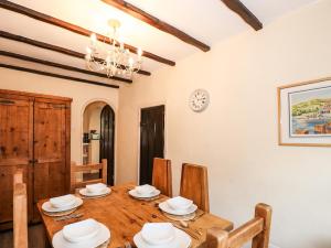 una sala da pranzo con tavolo e sedie in legno di Smithy Cottage at Bowland Bridge a Bowland Bridge Altre 9 foto