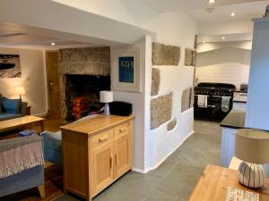 a kitchen and living room with a stone fireplace at 14 Boscaswell Downs in Lower Boscaswell