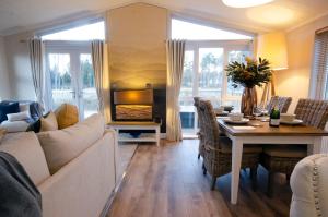 a living room with a couch and a table with a fireplace at Hollicarrs - The Rushes in Riccall