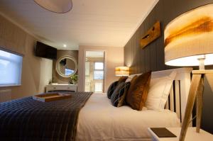 a bedroom with a bed and a lamp and a mirror at Hollicarrs - The Rushes in Riccall