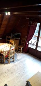 a room with a table and chairs and a tv at chalets montagnard in Jausiers +3 photos
