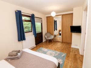 a bedroom with a bed and a window and a chair at Foxglove Lodge in Saltburn-by-the-Sea