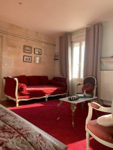 uma sala de estar com um sofá vermelho e uma mesa em Chambre Merlot, piscine et spa, proche St Emilion em Lugon et l’Ile du Carney