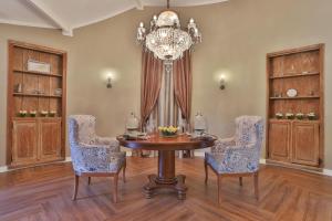 uma sala de jantar com uma mesa e cadeiras e um lustre em Villa Casato Residenza Boutique em Campos do Jordão