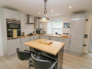 a kitchen with a wooden table and black chairs at Bryngolau in Pwllheli
