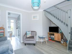 a living room with a chair and a staircase at Little Wash Cottage in Hunstanton