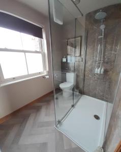 ein Bad mit Dusche, WC und Fenster in der Unterkunft Hazelwood Farm B&B in Easingwold