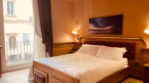 ein Schlafzimmer mit einem Bett und einem großen Fenster in der Unterkunft Le Club Boutique Hotel in Lecce
