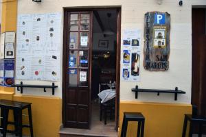 un restaurante con una puerta abierta y un cartel en la pared en Pensión San Marcos, en Arcos de la Frontera